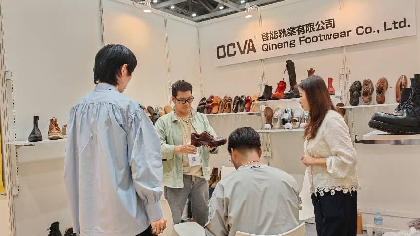 Qineng Footwear team discussing OCVA footwear samples with visitors at the FaW TOKYO booth