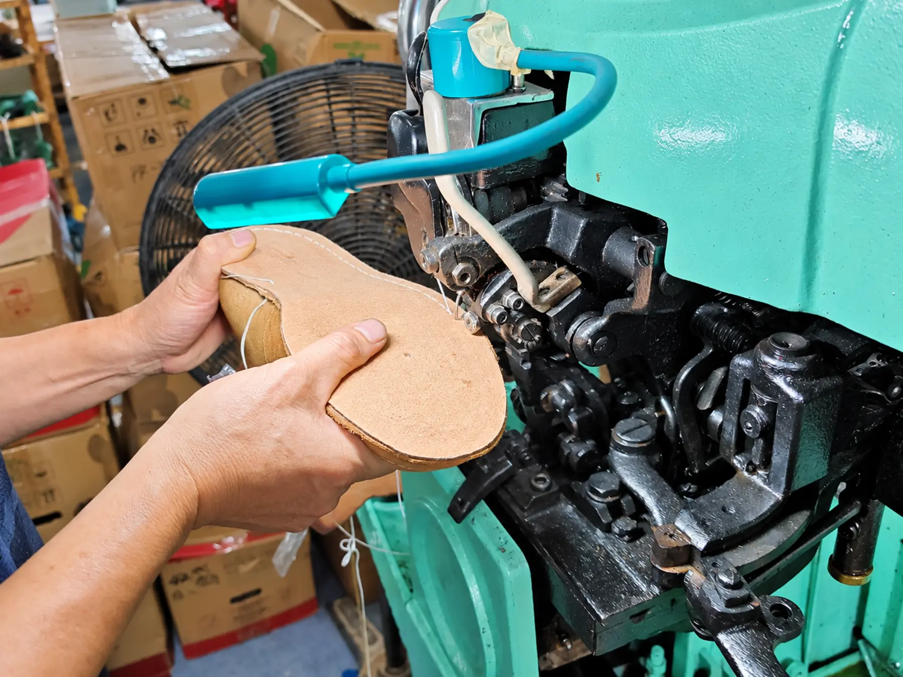 A footwear component being prepared at a Qineng workshop machine